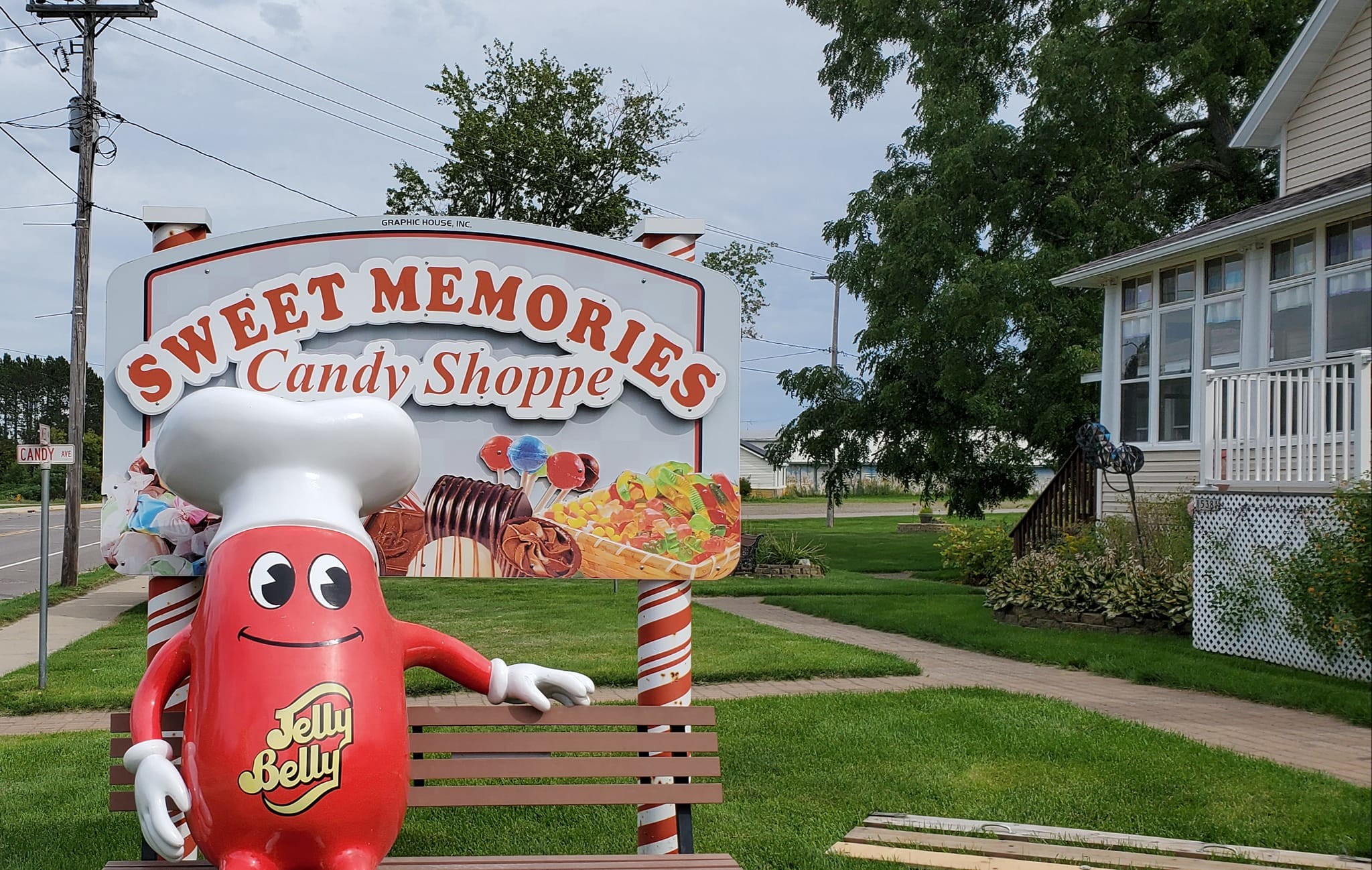 Mr. Jelly Belly sitting on a bench in front of Sweet Memories Candy Shoppe.